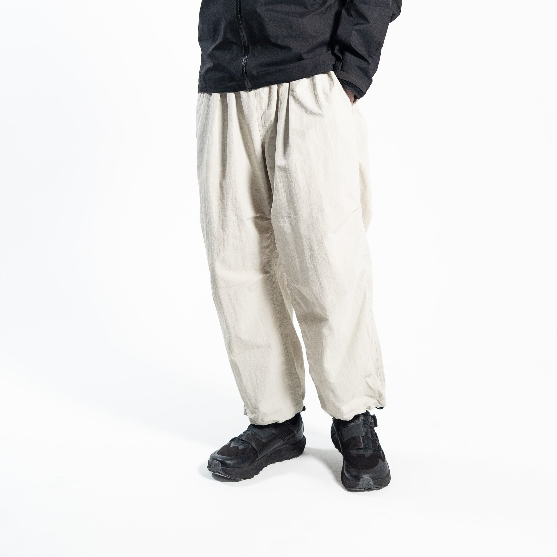 ホワイトのワイドトレッキングパンツ（Trail Wide Pants）を着用した男性