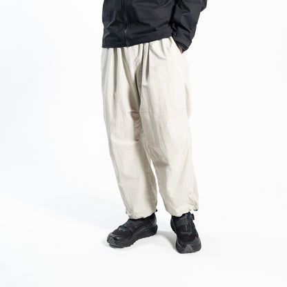ホワイトのワイドトレッキングパンツ（Trail Wide Pants）を着用した男性